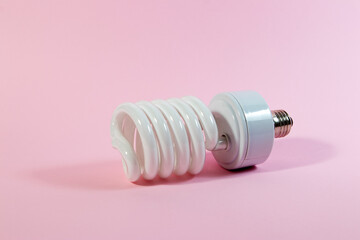 An energy saving fluorescent light bulb on a pink background © Branislava