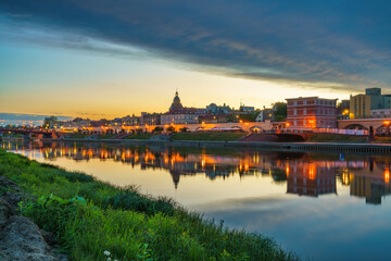 Obraz premium Gorzow Wielkopolski boulevard and tower of St. Mary's cathedral seen across Warta river. Poland