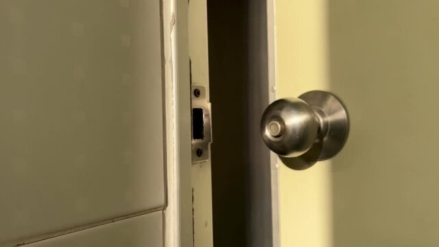 Man with white shirt exiting from toilet. Man open toilet door, holding door knop