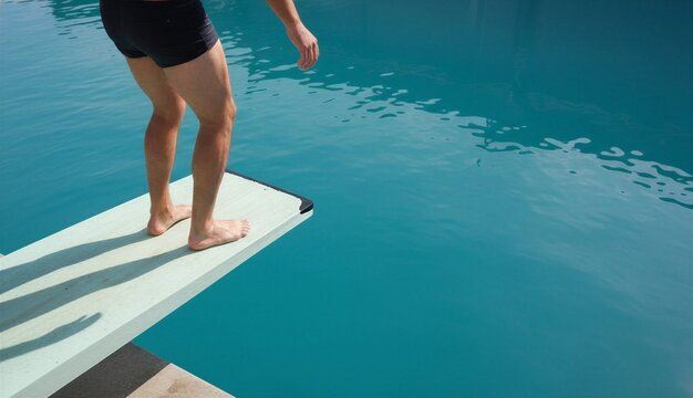 Man preparing to dive from diving board into clear blue pool  