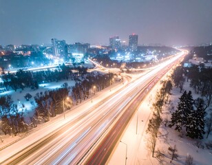 Obraz premium Bright Long Exposure Traffic Trails Crossing Snowy City Highway at Night