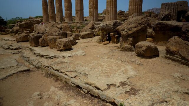Ruined Doric columns of the Temple of Heracles rising from scattered sandstone blocks at Valle dei Templi, Agrigento, Sicily, Italy