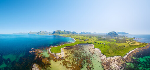 Fototapeta premium Drone view of the Arctic Ocean coastline, Lofoten Islands, Norway. A panoramic view of the northern summer. Scenic arctic landscape with beach, ocean and northern nature. Background and wallpaper.