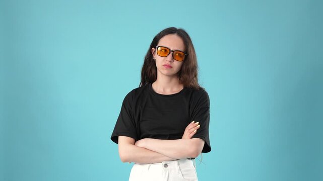 Young woman showing confusion gesture and crossing arms looking aside