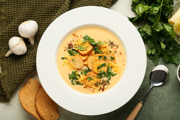 Bowl of tasty cheese soup with parsley and croutons on grunge background