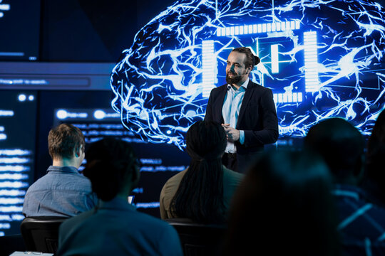 Professional businessman presenting AI neural networks concept during IT convention in auditorium, takes the stage for AI-driven sale pitch. Speaker presents machine learning tech to investors.