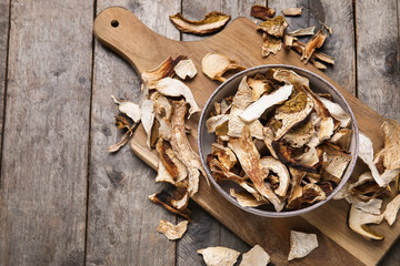 Fototapeta premium Bowl with tasty dried mushrooms on wooden background