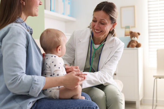 Mother with her baby having appointment with pediatrician in hospital, closeup. Doctor checking child with stethoscope
