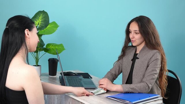 Manager taking cash money from client at office desk