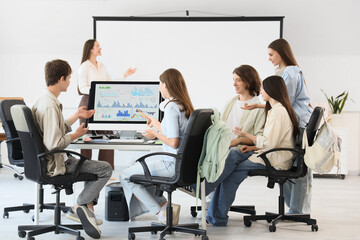 Naklejka premium Teenage students with teacher studying at school computer lab