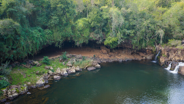 Forest waterfall and rocky stream inside Parque Natural Municipal Gruta India in Argentina.