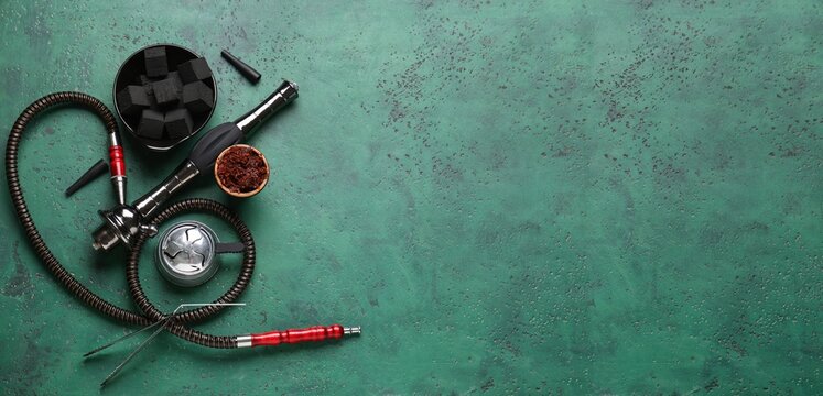 Parts of hookah and tobacco on green background with space for text