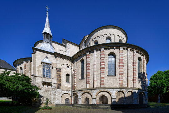 Romanesque architecture of St. Maria im Kapitol in Cologne, Germany. View of the cloverleaf choir and apse under a clear blue sky. High detail.