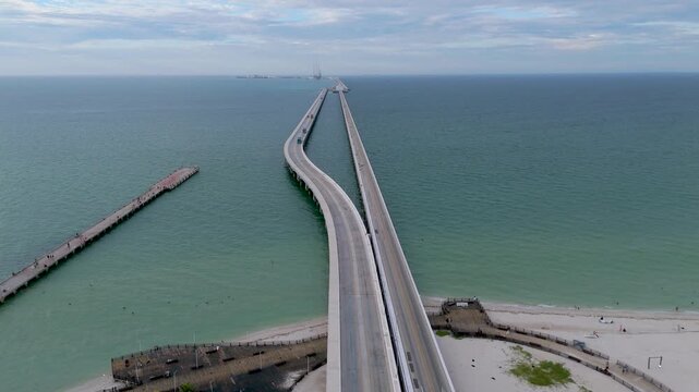 Aerial landscape shot captures a perspective of the immense arched viaduct pier stretching out to sea from the coast of Progreso, Mexico. 