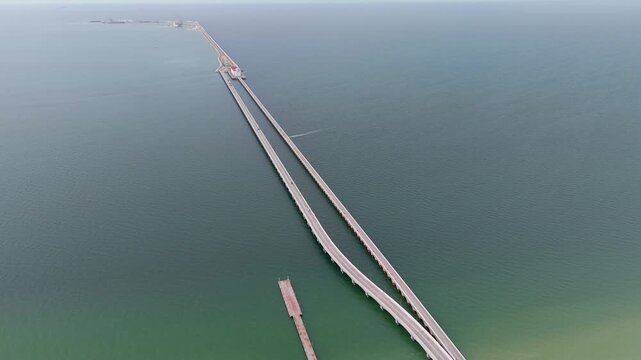 Aerial landscape shot captures a perspective of the immense arched viaduct pier stretching out to sea from the coast of Progreso, Mexico. 