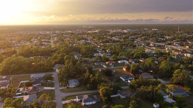 Overhead view of small town neighborhood in evening with single family houses, driveways and trees. Calm suburban living, property ownership and American dream lifestyle concept.