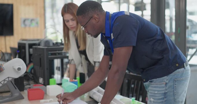Engineer and Product Designer Reviewing Technical Blueprints
