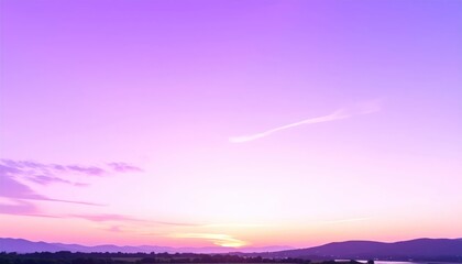 Obraz premium Vibrant Purple Sunset Over Rolling Hills and Distant Water.