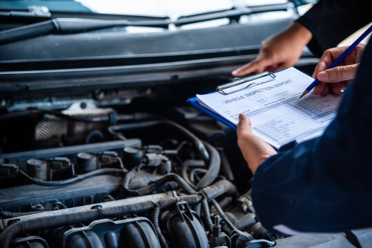 Close up Car Mechanic man hands repairing car auto repair shop. Close up hand man check engine oil level Locate dipstick, wipe clean, check dipstick level before fill up engine oil. open vehicle