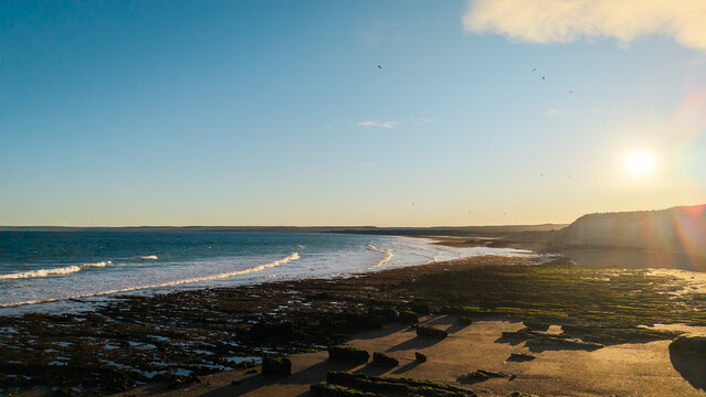 Wide Atlantic coastline with waves and sunset light at Playa Las Canteras in Patagonia Argentina.
