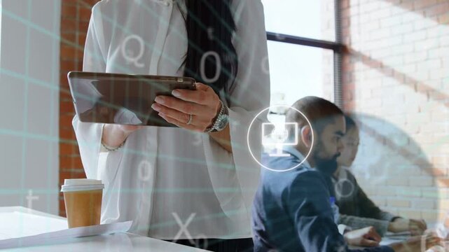 Standing woman tapping tablet at counter forming tech grid icons moving over team showing teamwork