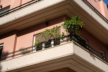 Fototapeta premium facade of a pink building with a corner balcony