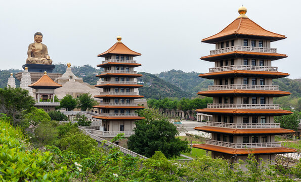 Fo Guang Shan Monastery in Kaohsiung, Taiwan. Grand Buddha statue overlooks traditional pagodas. Historic Buddhist temple complex nestled in lush hills.