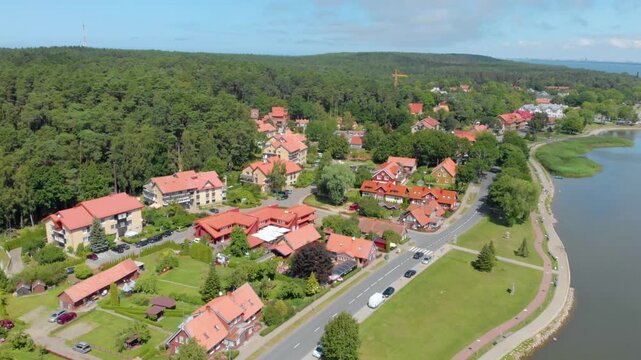 Drone footage capturing the picturesque coastal town of Juodkrantė, located on the unique Curonian sand dune spit that separates the Curonian Lagoon from the Baltic Sea.