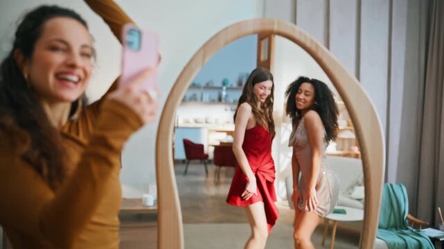Girl recording home party on smartphone closeup. Women wearing classy dresses