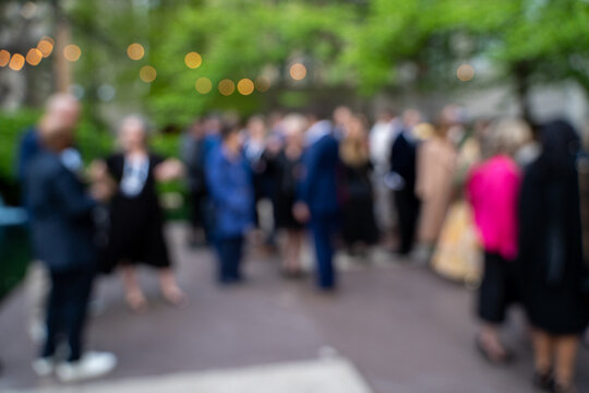 Blurred crowd at outdoor corporate networking event.