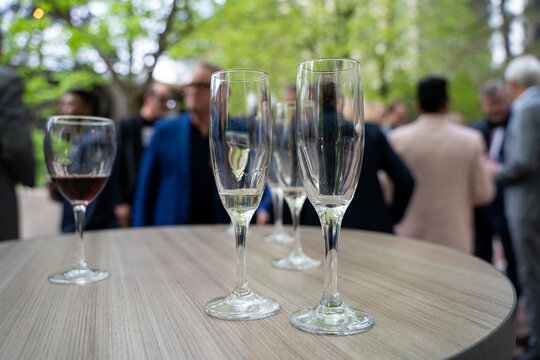 Empty champagne glasses at outdoor networking reception event.