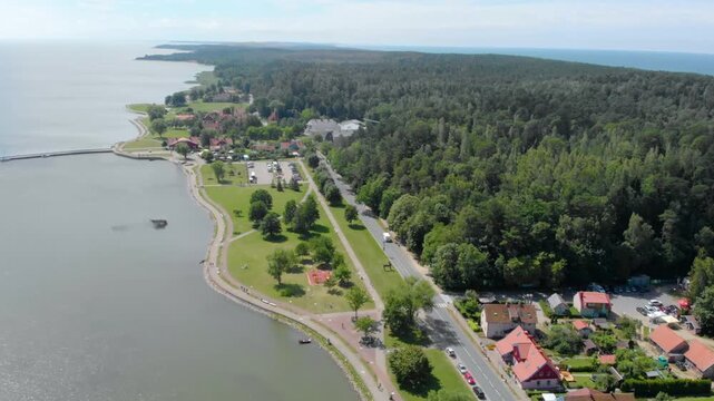 An aerial drone shot captures the picturesque landscape of Juodkrantė, a small settlement located on the Curonian Spit, a UNESCO World Heritage site in Lithuania.