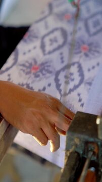 Making tenun ikat Bandar, Indonesia. An Indonesian woman weaving traditional fabric. Traditional weaving cotton in Indonesia.