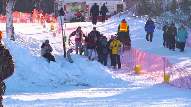 People in the snow walking to see sled dogs