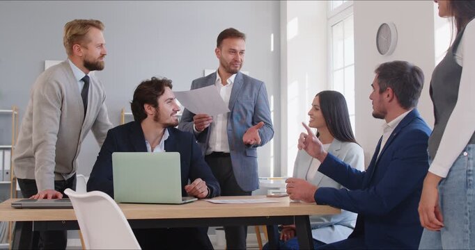 Business team meeting with manager leading presentation. Colleagues review notes during discussion, briefing and training together. Concept collaboration, strategy, and leadership communication.
