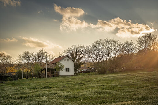 Countryside house in Sumadija, Serbia, standing beside orchards and grassy land, showing rural real estate, village living, and a family property in a Balkan landscape.