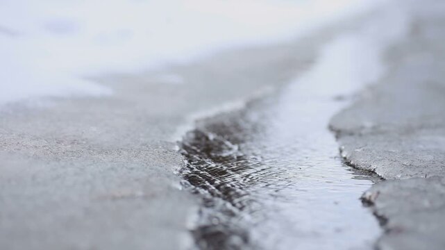 道路を流れる雪解け水