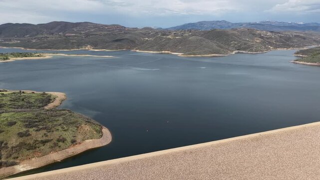 Wide aerial of Jordanelle Reservoir and dam in Heber Valley Utah in spring on cloudy day