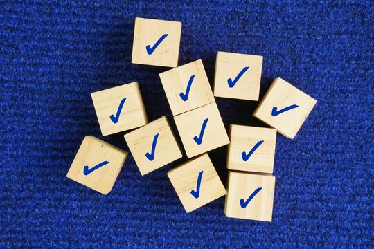Wooden cube with a symbol of the right sign. Symbolizes investigation, verification, inquiry, or finding the truth. Research, decision making, checking facts. business, decision-making, checklist 