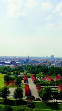 Vertical video. Copenhagen, Denmark. Kastellet star fortress with its distinctive pentagonal bastions and red barracks, Drone footage over green ramparts and surrounding moat under a bright summer sk