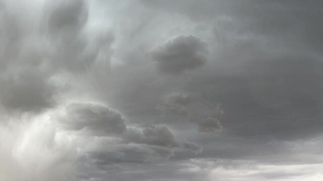 Expansive prairie storm clouds drifting across rural Alberta sky in changing weather conditions