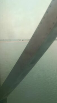 Train Crossing a Long River Bridge with Scenic Water View Through Window