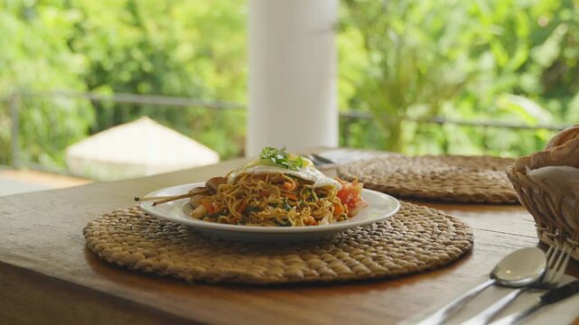 Traditional Indonesian mie goreng served with fried egg, vegetables, and savory spices.