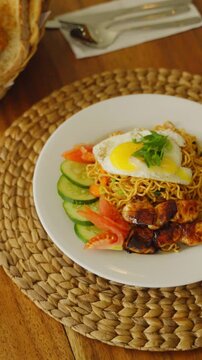 Traditional Indonesian mie goreng served with fried egg, vegetables, and savory spices.