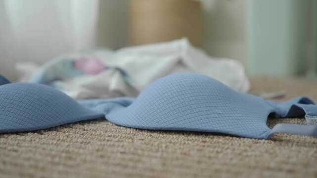Blue bra placed on the floor near white clothes