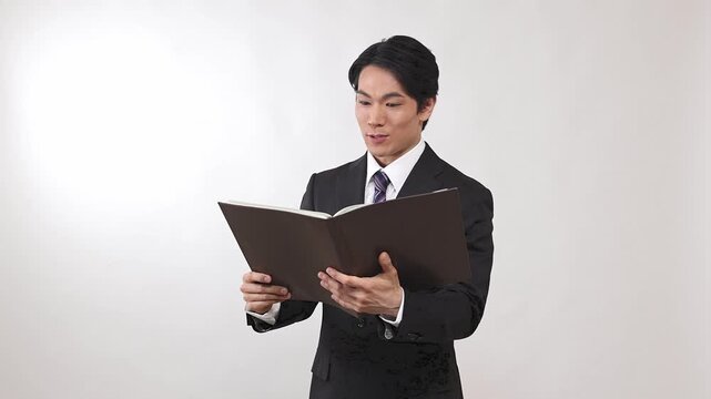 台本を読みながら商品やサービスを紹介するビジネスマン 白背景
