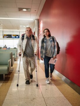 Bold red airport corridor background with travelers walking toward terminal gate for accessibility awareness, mobility independence and travel inclusivity campaigns
