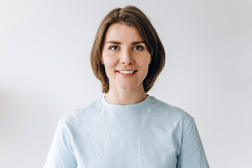 Fototapeta premium Portrait of beautiful cheerful young woman wearing casual clothes on white background