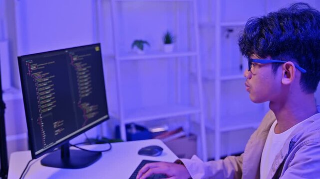 Smart Teenage Hacker Type Code On Monitor Screen Inside Blue Neon Room