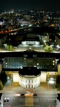 Vertical video. Oryol, Russia. The House of Soviets on Lenin Square, its illuminated Soviet-era administrative facade and rotunda entrance, Drone footage during a night flight over the historic city 